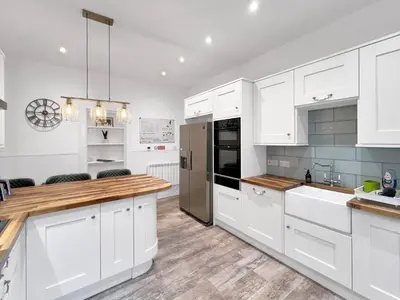 a kitchen with white cabinets and stainless steel appliances at No.3 The Villa in Oban