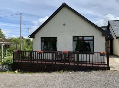 a house with a porch with flowers on it at Snowberry Cottage No 2 in Onich