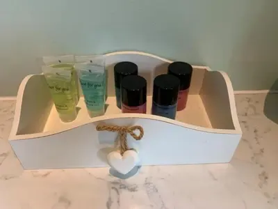a white shelf with four bottles of moisturizing cosmetics at Snowberry Cottage No 2 in Onich
