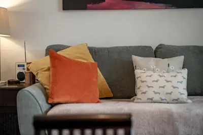 a gray couch with pillows on top of it at Heather Cottage, 2 bedroom in Comrie in Comrie