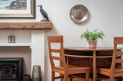 a dining room table with chairs and a bird on the wall at Heather Cottage, 2 bedroom in Comrie in Comrie