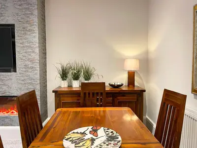 a dining room with a wooden table and chairs at 2Bed, Private Garden & Fireplace, Near Water of Leith in Edinburgh