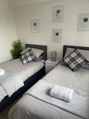 two beds sitting next to each other in a room at THE PAISLEY PENTHOUSE - ABBEY VIEW in Paisley