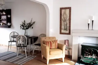 a living room with a chair and a table and a fireplace at Best location in town, it is all on the doorstep. in Ayr