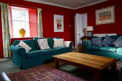 a living room with two couches and a coffee table at Rural Farmhouse on Kintyre, West Coast hidden gem in Kildalloig