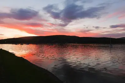 a body of water with a sunset in the background at An Cuilidh in Port Bannatyne