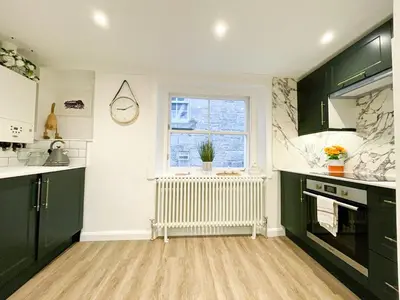 a kitchen with black and white cabinets and a window at Stunning Loft Apartment South Queensferry High St Bridge Views! in Queensferry