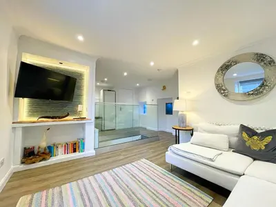a living room with a white couch and a mirror at Stunning Loft Apartment South Queensferry High St Bridge Views! in Queensferry