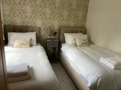 two beds sitting next to each other in a bedroom at Walled Garden Lodges Loch Lomond in Balloch