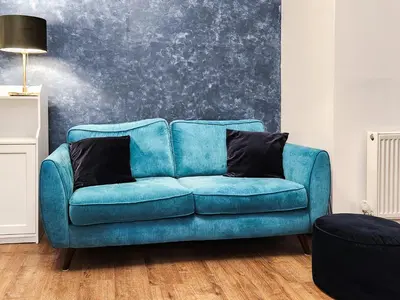 a blue couch with two pillows on it in a room at Riverside Cottage in Larkhall