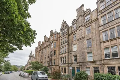 a row of buildings with cars parked in front of them at Beautiful 2 Bed 2 Bath Flat overlooking Meadows Park in Edinburgh
