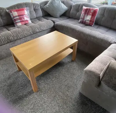 a couch with a wooden coffee table in a living room at Croft View in Taynuilt