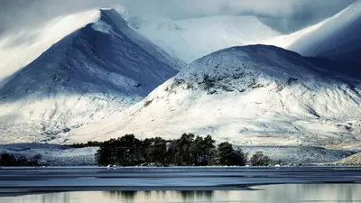 a snow covered mountain with a lake in front of it at Corrie Apartment, Kinlochlaich House in Appin