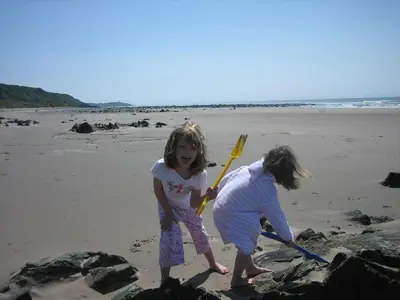 two little girls playing in the sand on the beach at Garden Cottage in Stranraer