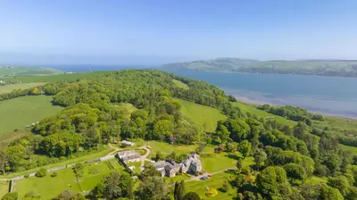 an aerial view of a mansion on a hill next to a lake at Garden Cottage in Stranraer
