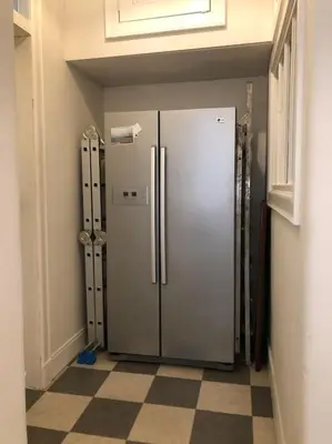 a refrigerator in a room with a checkered floor at Spacious 3 bed flat in the heart of the west end. in Glasgow