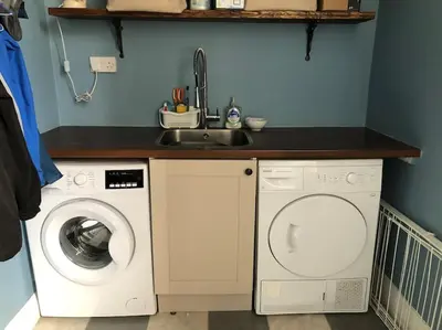 a kitchen with a sink and a washing machine at Spacious 3 bed flat in the heart of the west end. in Glasgow