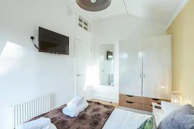 a bedroom with a bed and a tv on the wall at Squirrel Lodge 41 with Hot Tub in Newton Stewart