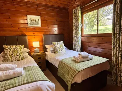 a bedroom with two beds in a log cabin at Lady Galloway 27 with Hot Tub in Newton Stewart