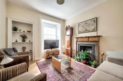 a living room with a couch and a fireplace at charm & character on historic Rose Street in Edinburgh