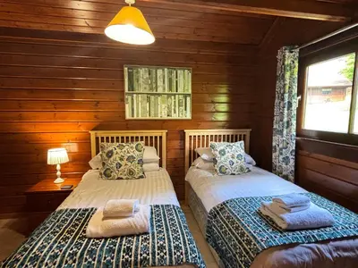 a bedroom with two beds in a log cabin at Lady Galloway 30 with Hot Tub in Newton Stewart