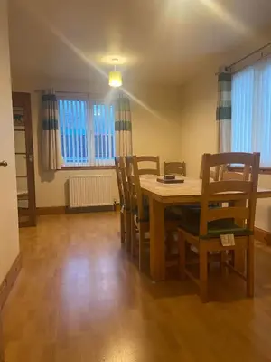 a dining room with a wooden table and chairs at Cosy detached house in central location in Oban