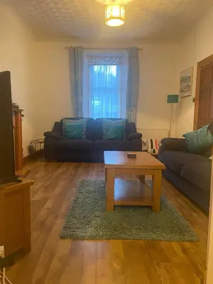 a living room with a couch and a coffee table at Cosy detached house in central location in Oban