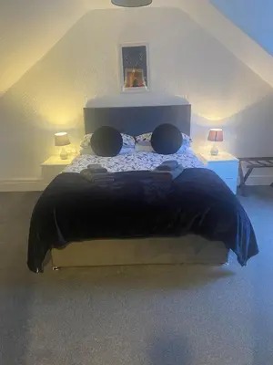 a bedroom with a large bed in a attic at Cosy detached house in central location in Oban