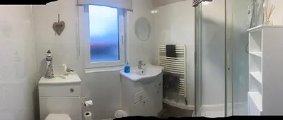 a white bathroom with a sink and a shower at Cosy detached house in central location in Oban