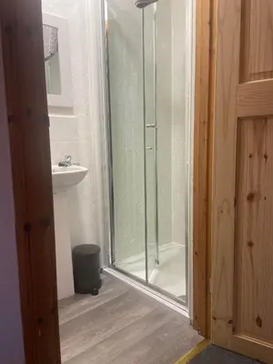 a glass shower in a bathroom with a sink at Cosy detached house in central location in Oban