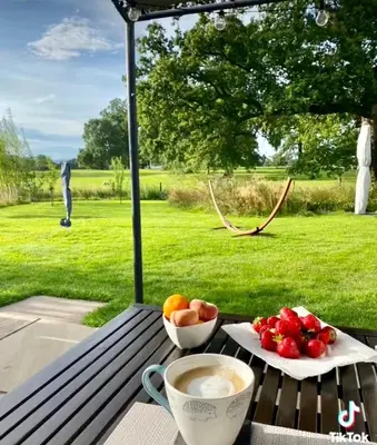 a table with a bowl of fruit and a cup of coffee at Poachers Hut at Keepers Cottage - Hot Tub & Pizza Oven - Trossachs in Port of Menteith