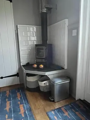 a kitchen with a stove in the corner of a room at Poachers Hut at Keepers Cottage - Hot Tub & Pizza Oven - Trossachs in Port of Menteith