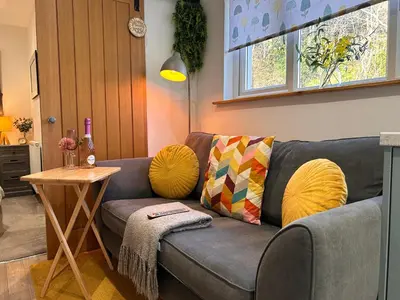 a living room with a gray couch with yellow pillows at Glenshee Annexe, Oban. in Oban