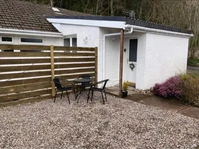 a table and chairs in front of a house at Glenshee Annexe, Oban. in Oban