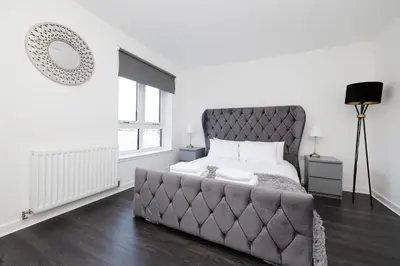 a bedroom with a large bed and a large window at Stylish 3BR Home with Garden & Free Parking - Near O2 Academy & City Centre in Glasgow