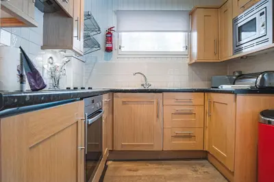 a kitchen with wooden cabinets and a sink at Crieff Hydro Self Catering in Crieff
