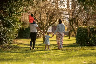 two adults and a child walking in a park at Crieff Hydro Self Catering in Crieff