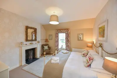 a living room with a white couch and a fireplace at High Clachan Farmhouse in Stranraer