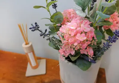a white vase filled with pink flowers on a table at The Botanics Residence in Edinburgh