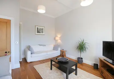 a living room with a white couch and a table at The Botanics Residence in Edinburgh