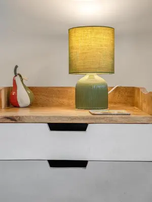 a lamp on a wooden shelf with a vase at Cheerful Stays: 4 Bedroom Cottage in Arrochar in Arrochar