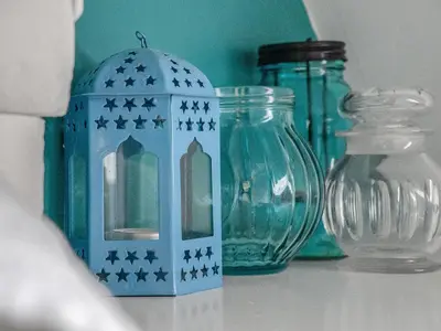 a shelf with glass jars and a blue candle holder at Cheerful Stays: 4 Bedroom Cottage in Arrochar in Arrochar