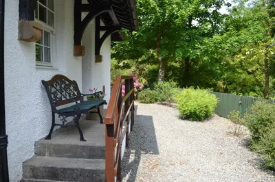 a bench sitting on the porch of a house at Home Farm Cottages, Glendaruel, Argyll. Scotland in Clachan of Glendaruel