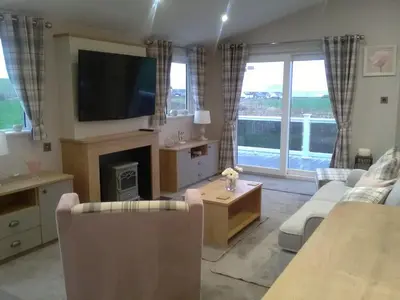 a living room with a fireplace and a tv at Turnberry lodge in Girvan