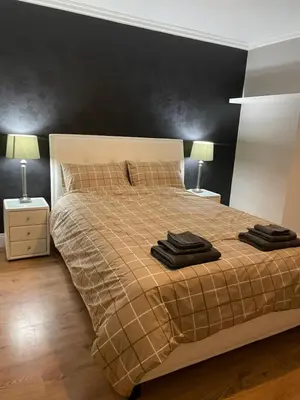 a bedroom with a bed with black walls and two lamps at Windsor House in Falkirk