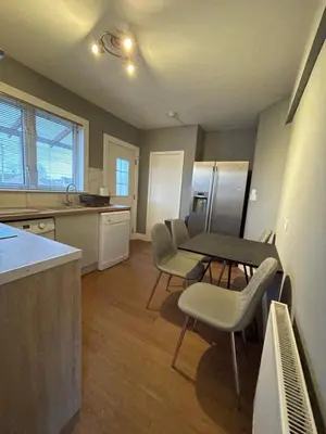 a kitchen with a table and chairs in a kitchen at Windsor House in Falkirk