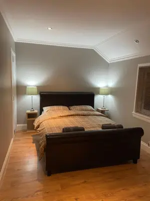 a bedroom with a bed with two lamps on two tables at Windsor House in Falkirk