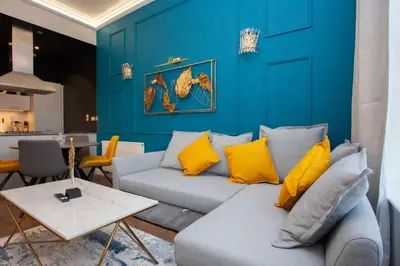 a living room with a couch and a blue wall at Stunning One bed with parking in City Centre in Glasgow