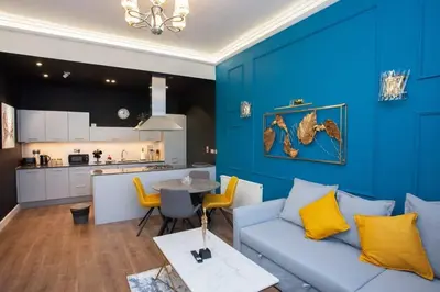 a blue living room with a couch and a table at Stunning One bed with parking in City Centre in Glasgow
