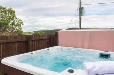 a bath tub sitting on top of a fence at Keepers Lodge with Hot Tub in Forgandenny